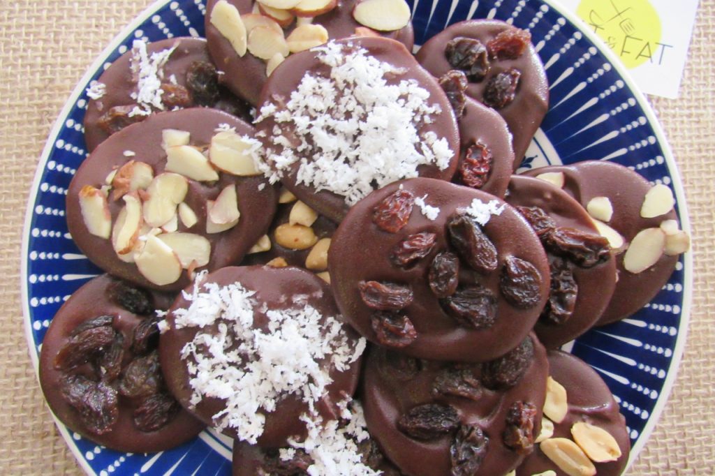 Medalhas de Chocolate com passas, amendoim, lascas de amêndoas ou de coco seco ralado.
