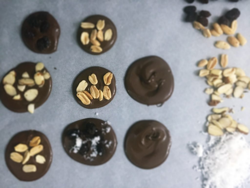 Para o preparo das Medalhas de Chocolate: chocolate meio amargo derretido, em formato redondo e recheado com passas, coco seco ralado, amendoim ou amêndoas.
