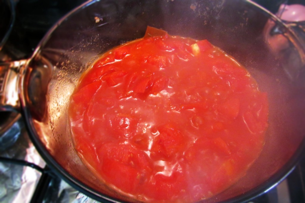 Suco do tomate após 20 minutos em fogo baixo dentro de uma panela com tampa.