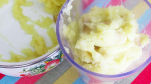 Batatas amassadas, leite e manteiga bem misturados para serem triturados e homogeneizados no liquidificador.